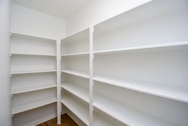a view of walk in closet with empty racks