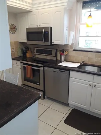 a kitchen with stainless steel appliances a stove a sink and a microwave