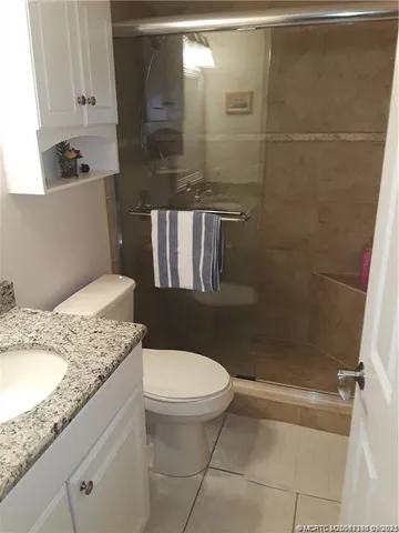 a bathroom with a granite countertop sink a toilet and shower
