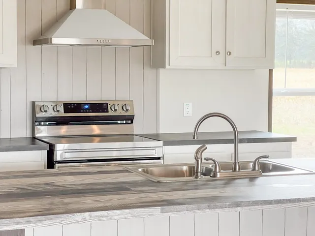 a kitchen with granite countertop white cabinets and a sink