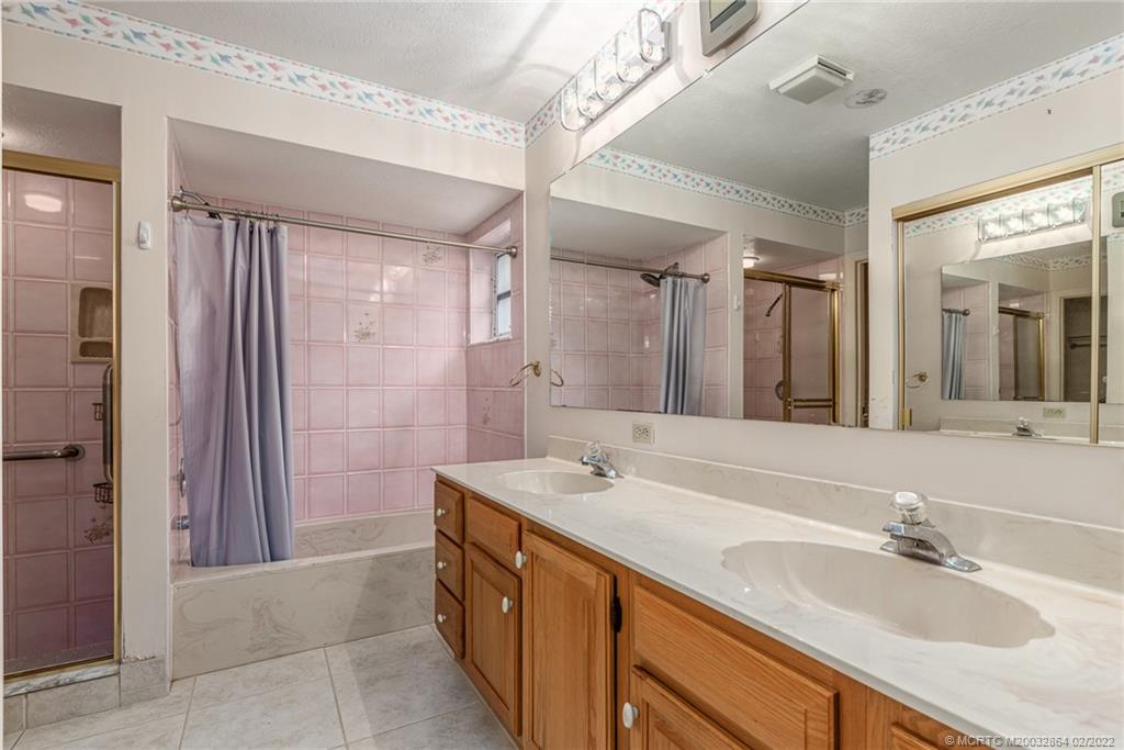 1214 Southwest Locks Road Stuart, FL 34997 - Photo 12 of 29 a bathroom with a sink double vanity granite tub shower and a mirror