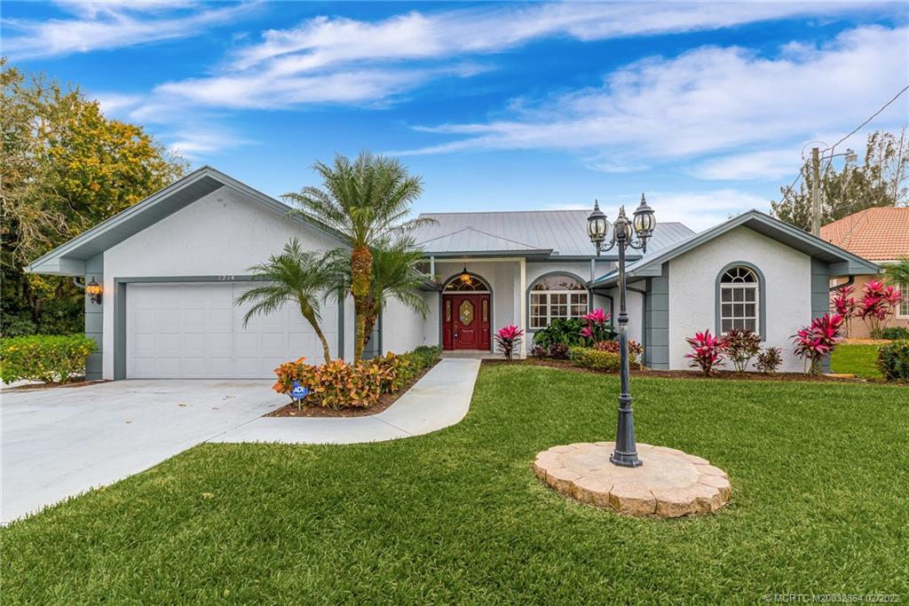 1214 Southwest Locks Road Stuart, FL 34997 - Photo 2 of 29 a front view of a house with a garden and yard