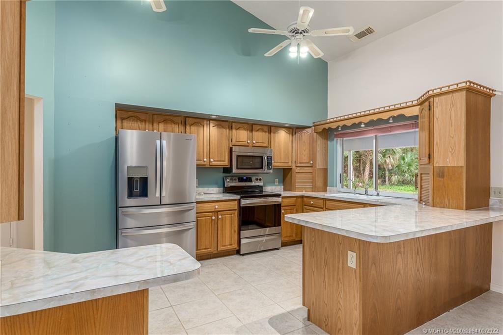 1214 Southwest Locks Road Stuart, FL 34997 - Photo 10 of 29 a kitchen with stainless steel appliances granite countertop a sink and a refrigerator