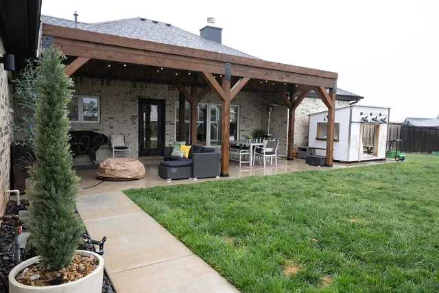 a view of a patio with table and chairs with wooden floor and fence