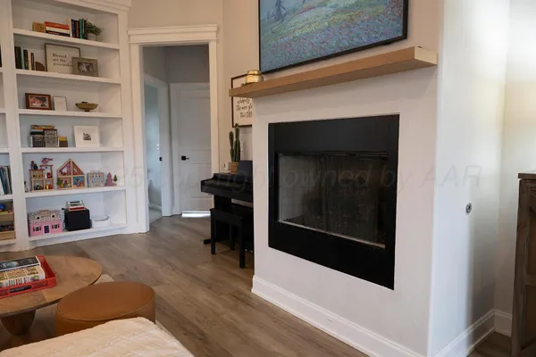 a living room with a fireplace and a wooden floor