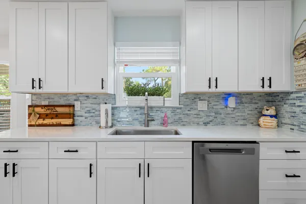 a kitchen with stainless steel appliances white cabinets and a sink