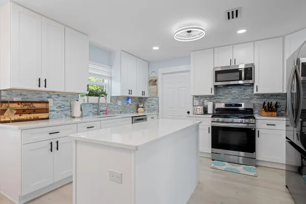 a kitchen with stainless steel appliances a stove sink microwave and cabinets