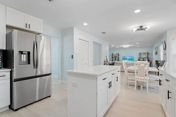 a large white kitchen with cabinets and stainless steel appliances