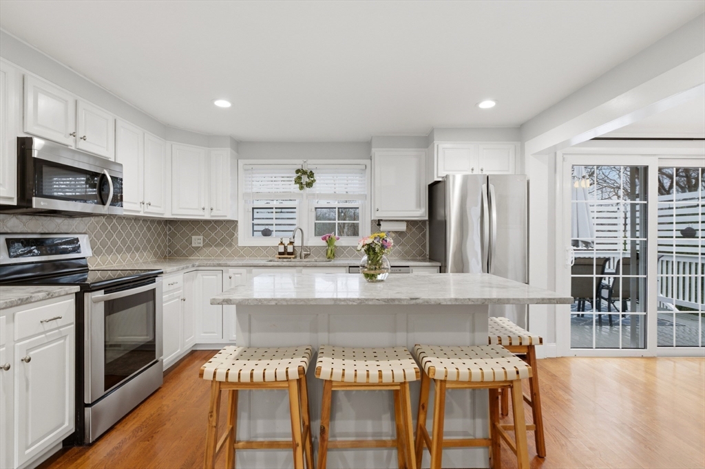 7 Paulette Drive Danvers, MA 01923 - Photo 8 of 25 a kitchen with stainless steel appliances granite countertop a stove top oven a sink and a refrigerator