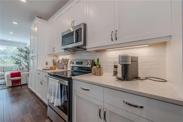 a kitchen that has a lot of cabinets a sink and a stove in it