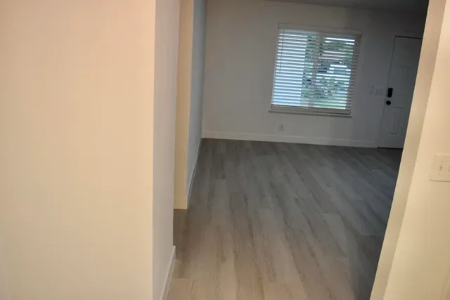 a view of a small space with wooden floor and a window