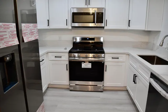 a kitchen with stainless steel appliances a stove a microwave and cabinets