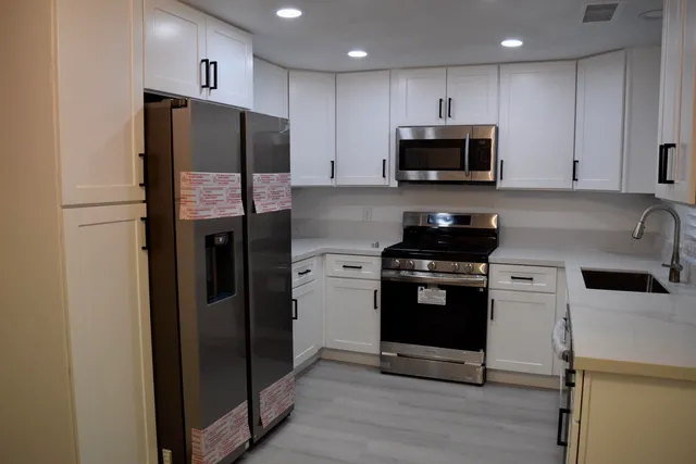a kitchen with a refrigerator and a stove top oven