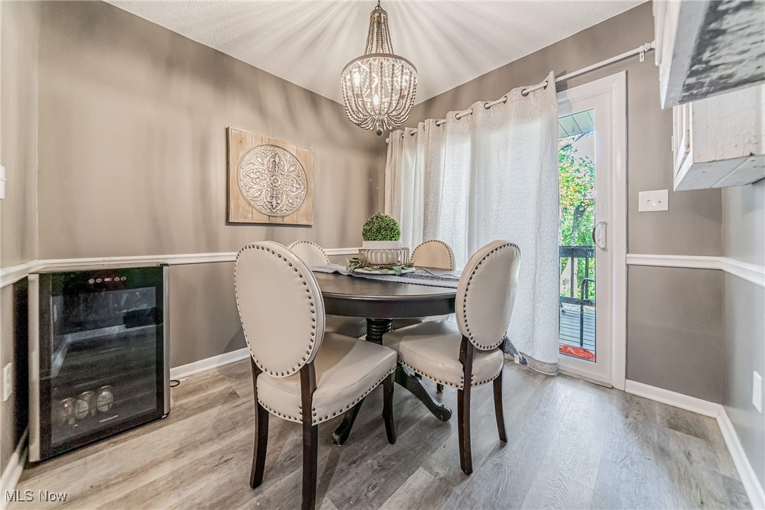 595 Moorfield Road Fairlawn, OH 44313 - Photo 15 of 50 Dining space with beverage cooler, light wood-style floors, and a chandelier