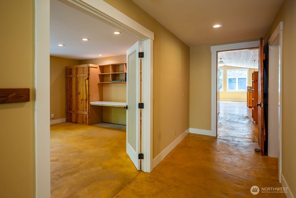 343 Burt Road Lopez Island, WA 98261 - Photo 16 of 39 a view of a hallway with wooden floor and a living room