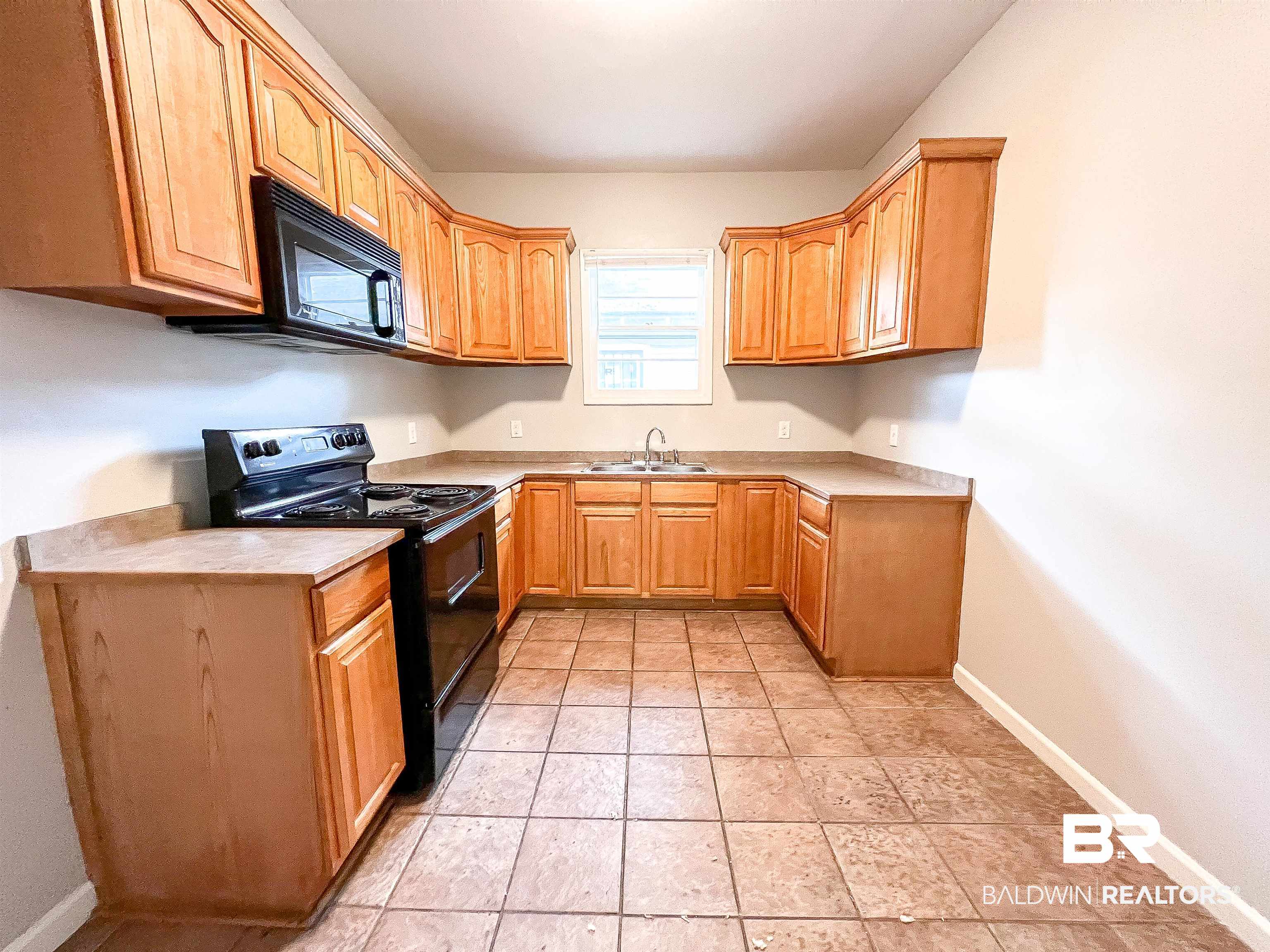 1164 Seneca Street Mobile, AL 36605 - Photo 8 of 22 Kitchen featuring light tile patterned floors, light countertops, a sink, black appliances, and baseboards