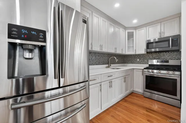 a kitchen with stainless steel appliances granite countertop a refrigerator sink and stove