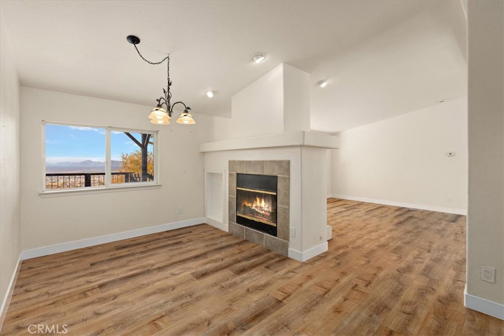 42557 Gibbel Road Hemet, CA 92544 - Photo 13 of 39 a view of a livingroom with a fireplace a chandelier and wooden floor