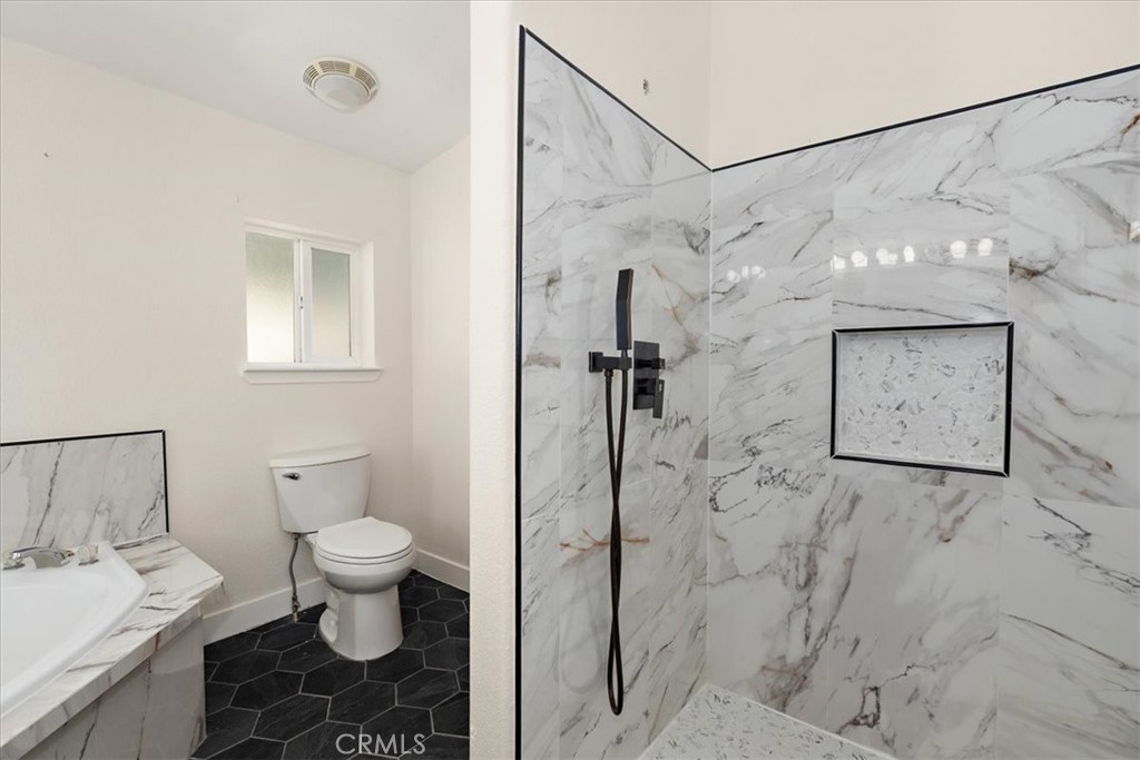 42557 Gibbel Road Hemet, CA 92544 - Photo 30 of 39 a bathroom with a granite countertop sink toilet and shower