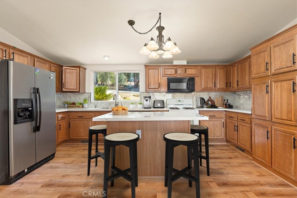 42557 Gibbel Road Hemet, CA 92544 - Photo 9 of 39 a kitchen with refrigerator cabinets dining table and chairs