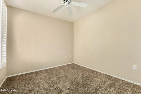 an empty room with a chandelier fan and closet