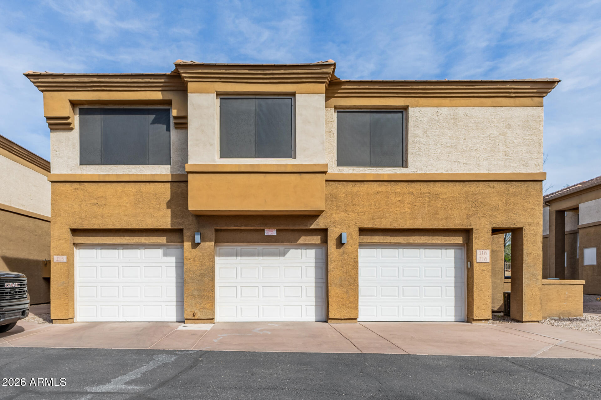 1445 East Broadway Road, Unit 116 Tempe, AZ 85282 - Photo 3 of 36 a front view of a house with a garage