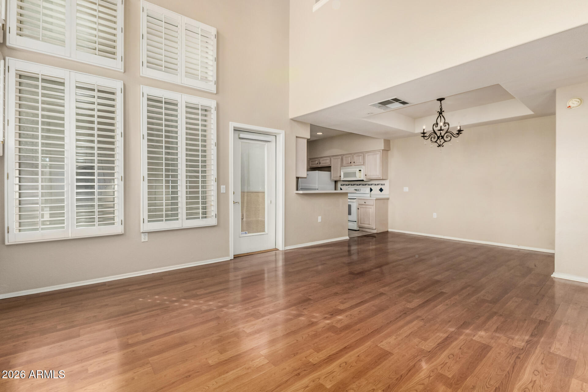 1445 East Broadway Road, Unit 116 Tempe, AZ 85282 - Photo 8 of 36 a view of an empty room with a window and wooden floor