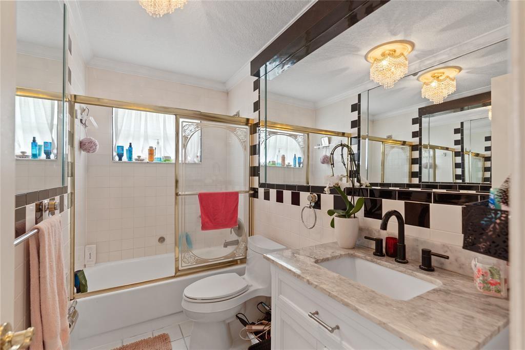 2670 Northeast 47th Street Lighthouse Point, FL 33064 - Photo 8 of 12 a bathroom with a granite countertop sink mirror vanity and toilet