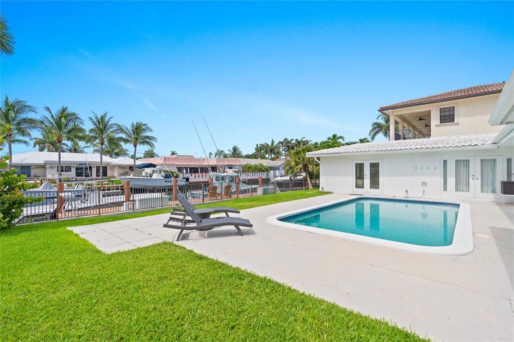 2670 Northeast 47th Street Lighthouse Point, FL 33064 - Photo 10 of 12 a view of pool and bench in front of house
