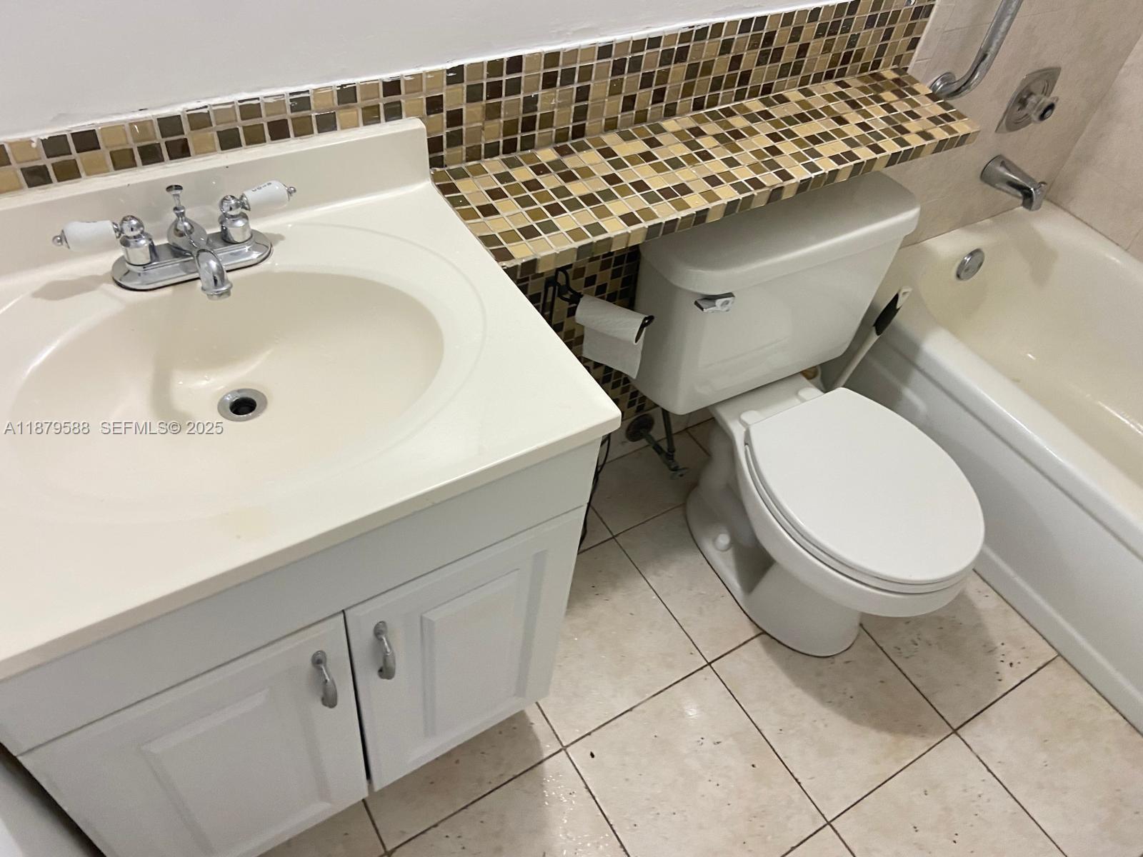 8 Fanshaw A, Unit 8 Boca Raton, FL 33434 - Photo 7 of 10 a bathroom with a sink a toilet and a mirror