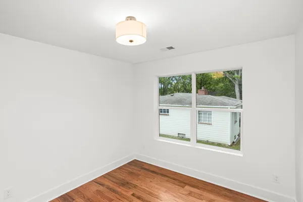 a view of a small space with wooden floor and a window