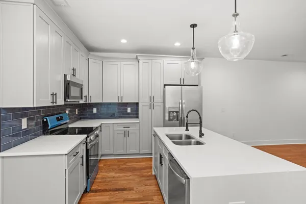 a kitchen with a sink stove and cabinets