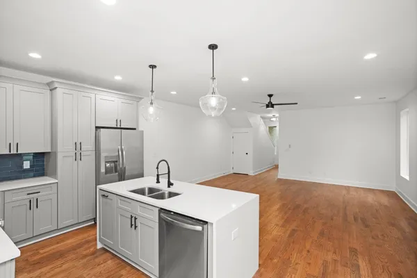 a kitchen that has a sink a stove and cabinets
