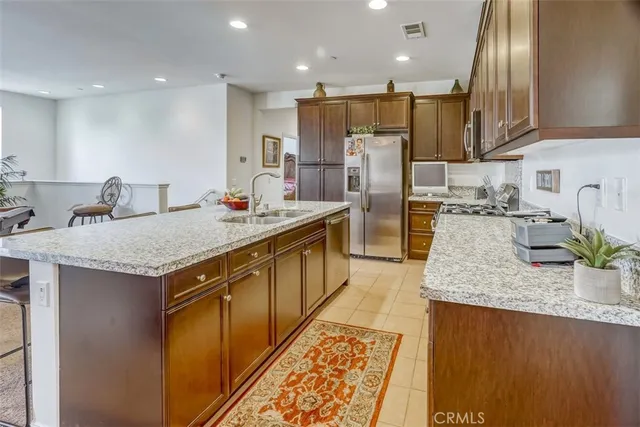 a kitchen with stainless steel appliances granite countertop a sink refrigerator and microwave