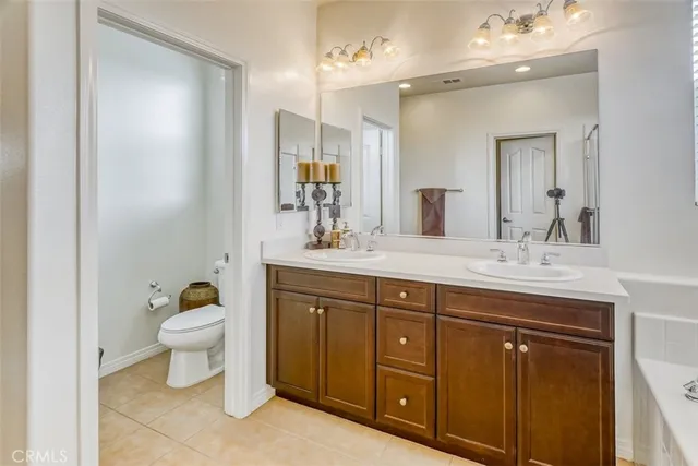 a bathroom with a toilet a sink a vanity and mirror