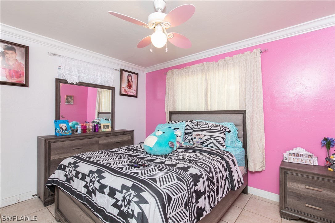 7467-69 Field Road, Unit 69 Fort Myers, FL 33967 - Photo 11 of 35 a bedroom with a bed and a chandelier