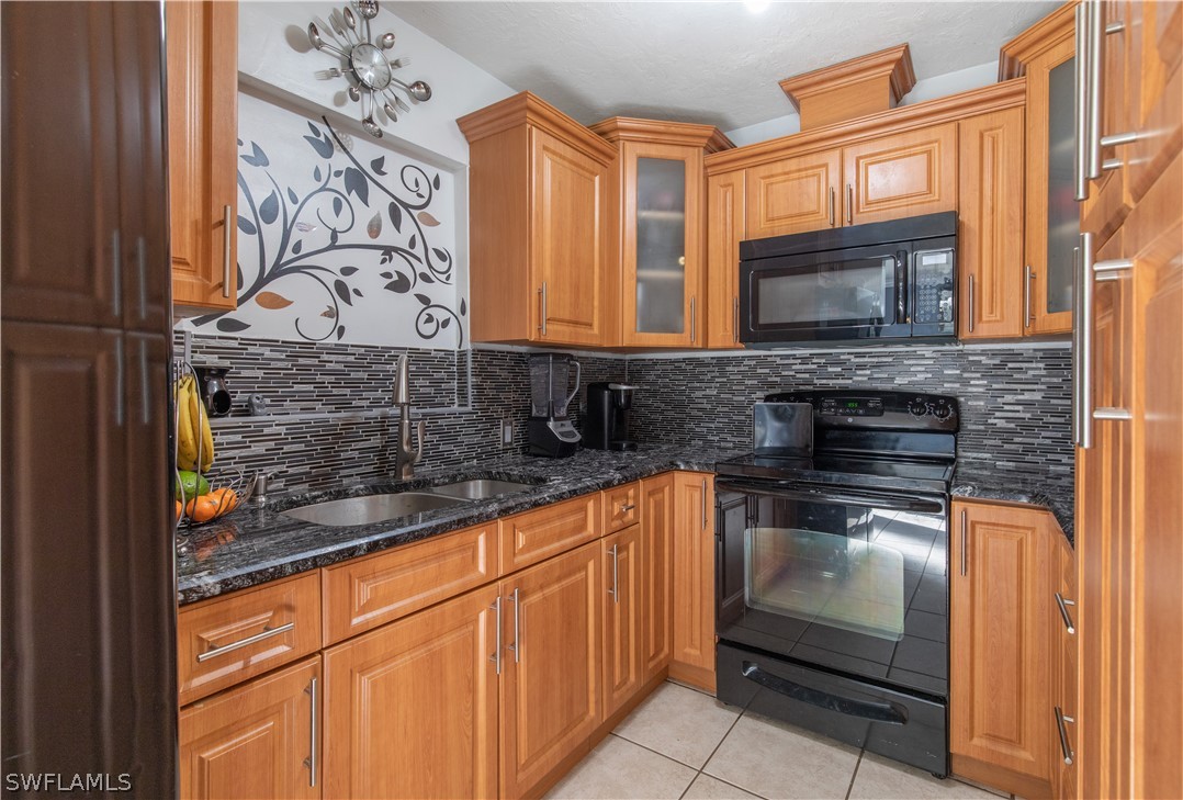 7467-69 Field Road, Unit 69 Fort Myers, FL 33967 - Photo 18 of 35 a kitchen with stainless steel appliances granite countertop a stove and a microwave oven