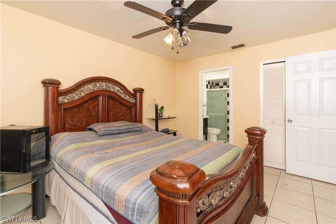 7467-69 Field Road, Unit 69 Fort Myers, FL 33967 - Photo 34 of 35 a bedroom with a bed and a chandelier