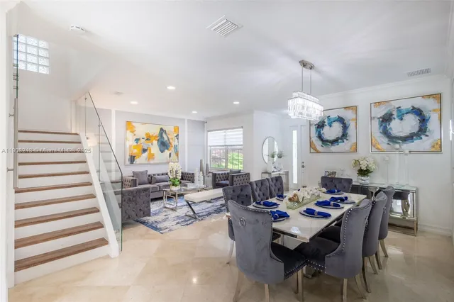a dining room with furniture a chandelier and wooden floor