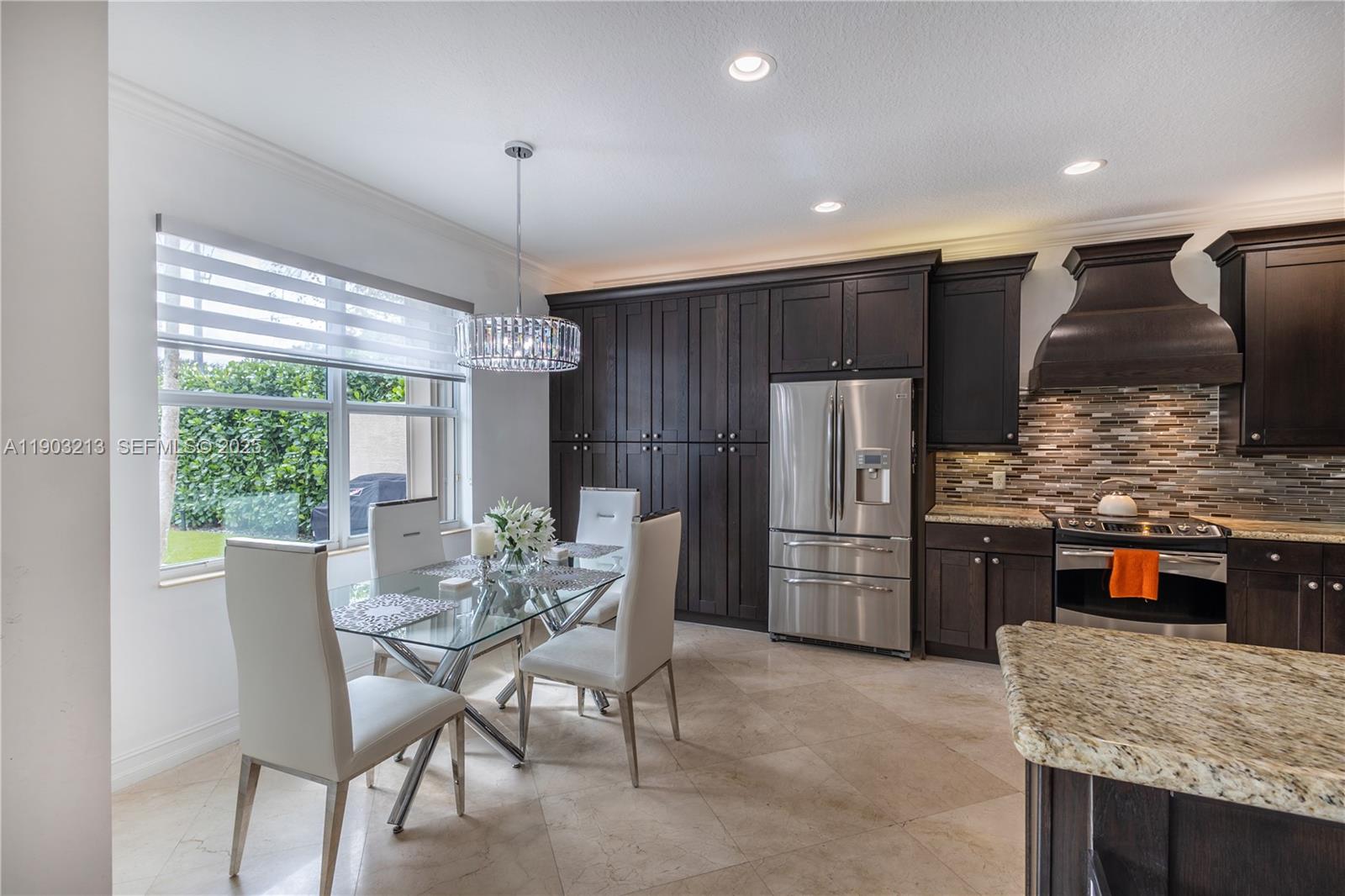 8292 Triana Point Avenue Boynton Beach, FL 33473 - Photo 23 of 60 a kitchen with refrigerator a sink and chairs