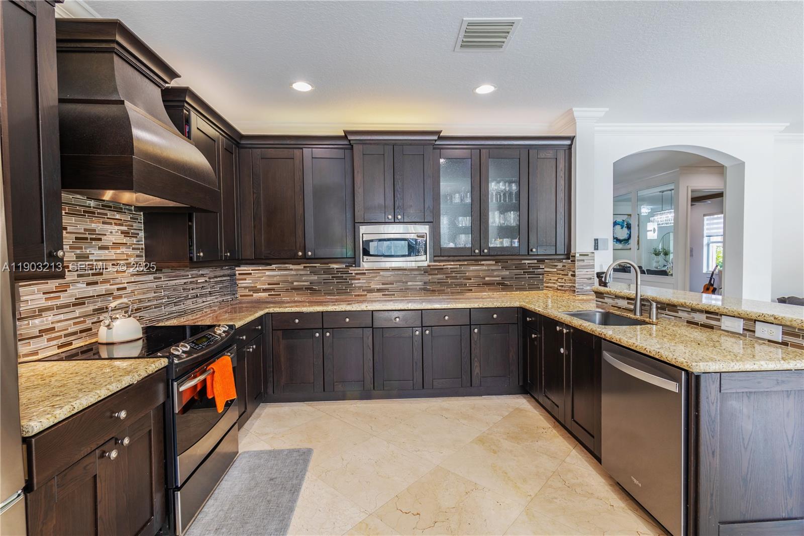 8292 Triana Point Avenue Boynton Beach, FL 33473 - Photo 24 of 60 a kitchen with stainless steel appliances granite countertop wooden cabinets a sink and dishwasher