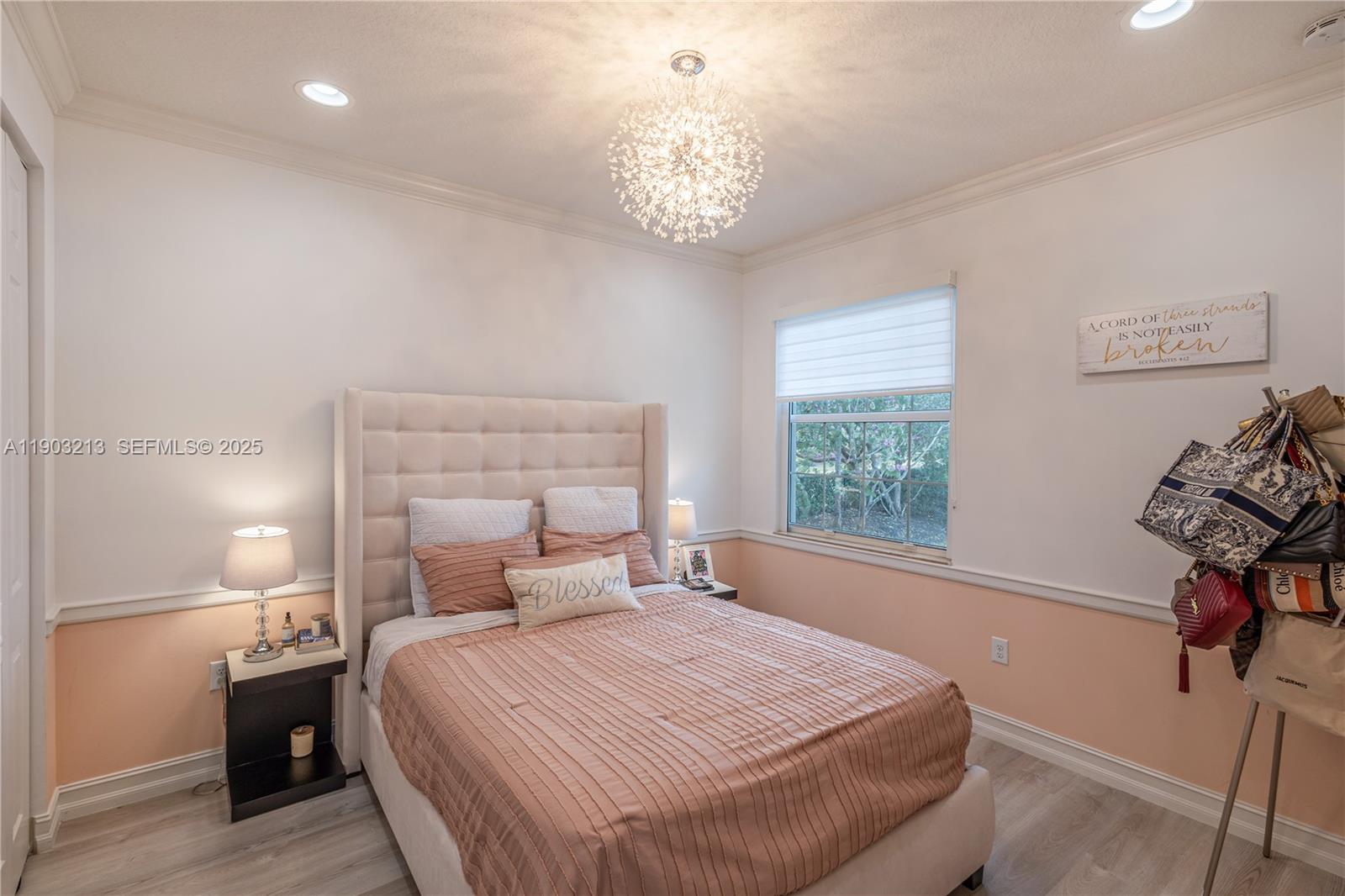 8292 Triana Point Avenue Boynton Beach, FL 33473 - Photo 32 of 60 a bedroom with a bed and a chandelier