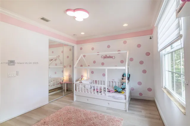 a bedroom with bed tv and a window