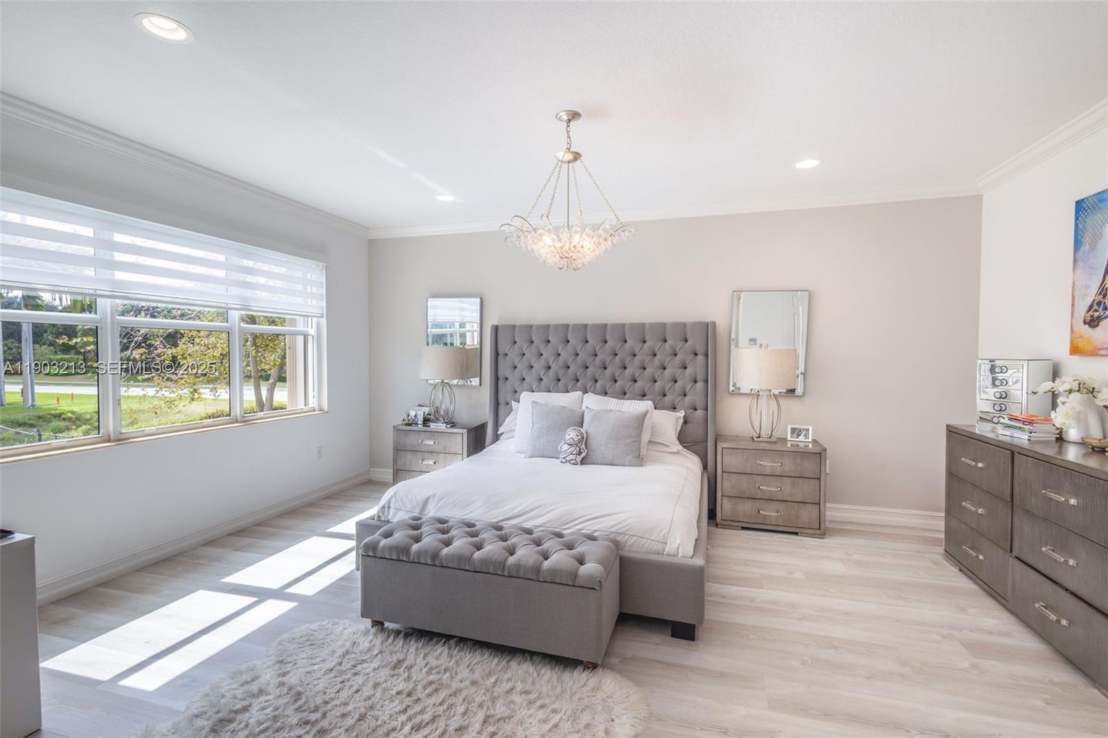 8292 Triana Point Avenue Boynton Beach, FL 33473 - Photo 46 of 60 a bedroom with a large bed and a chandelier