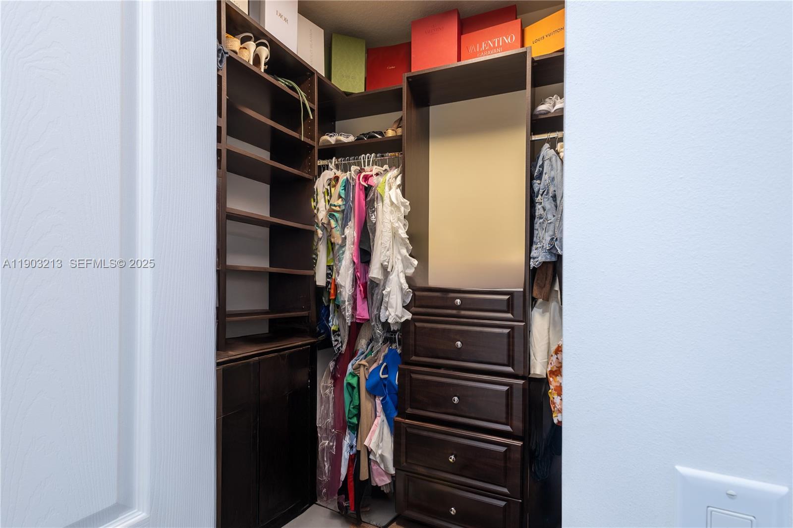 8292 Triana Point Avenue Boynton Beach, FL 33473 - Photo 48 of 60 a view of walk in closet with clothes and shoes