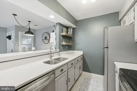 a kitchen with a sink and a clock on the wall