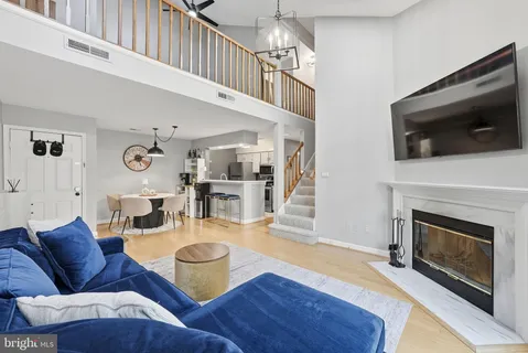 a living room with furniture a flat screen tv and kitchen view