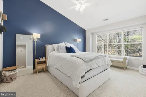 a bedroom with a bed and a large window