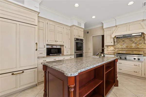 a kitchen with granite countertop a sink stove and refrigerator