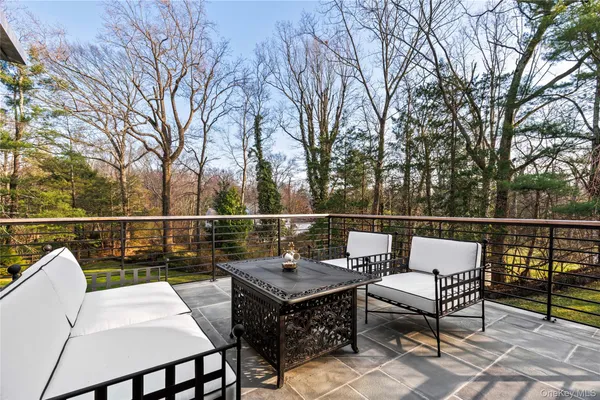 a balcony with wooden floor table and chairs